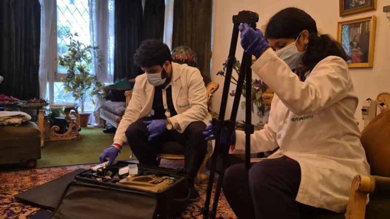 Two EyeSetu technicians unpacking portable diagnostic equipment in a patient's living room