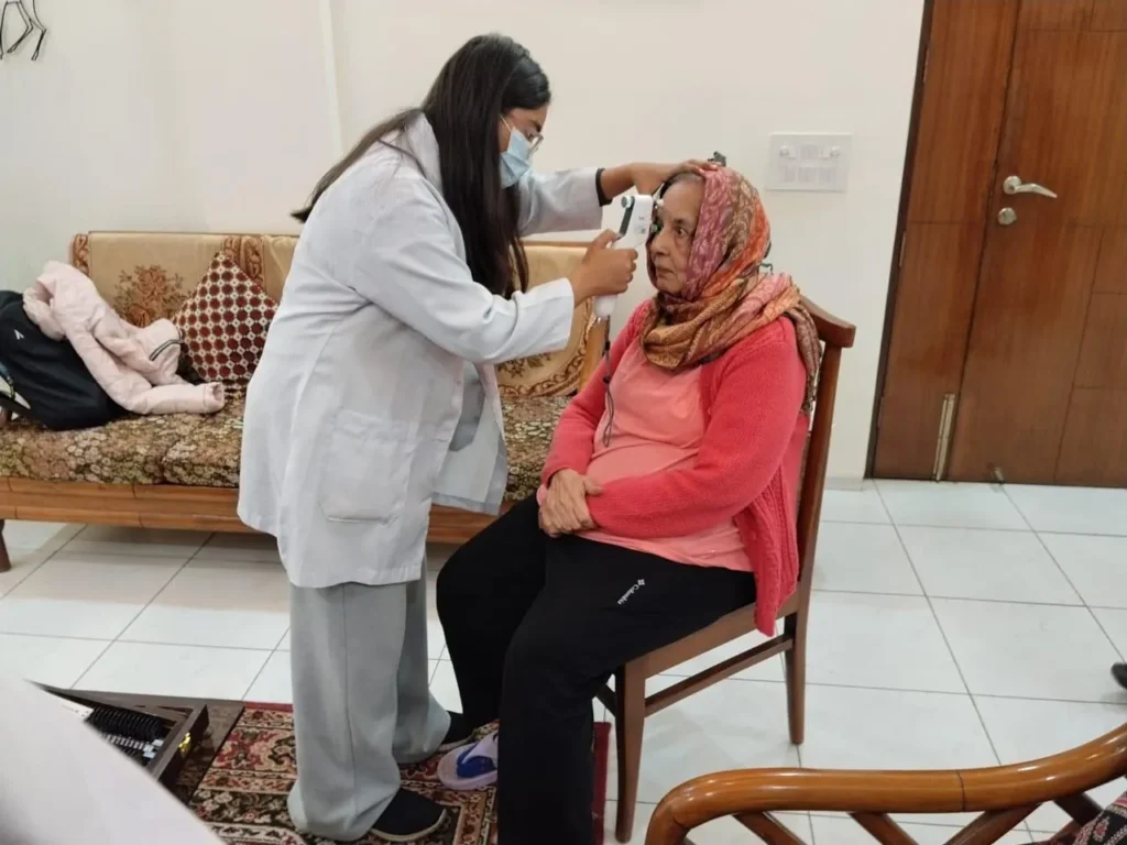 Optometrist checking an elderly woman's eyes at home