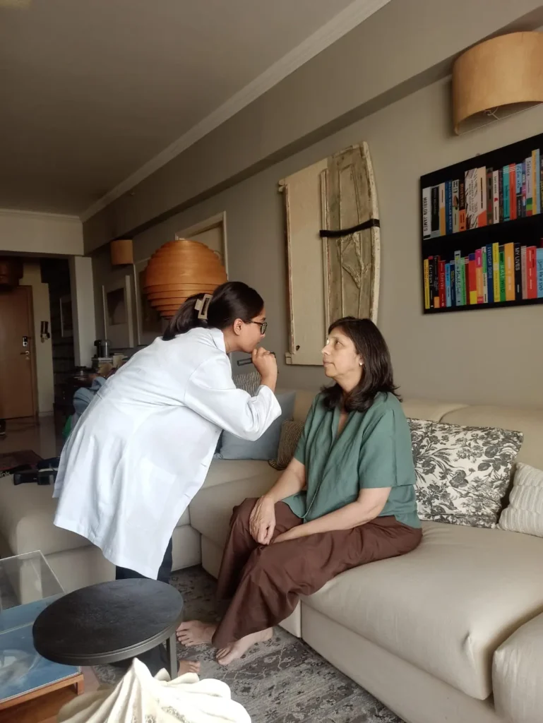 Optometrist examining a woman on her living-room sofa