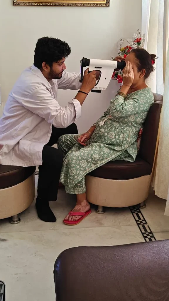 Optometrist using a portable eye scanner on a seated patient