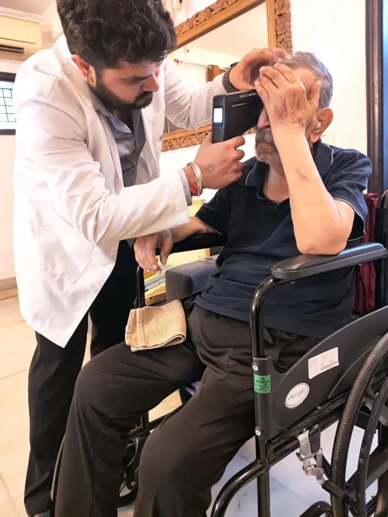 Doctor examining a patient seated in a wheelchair at home