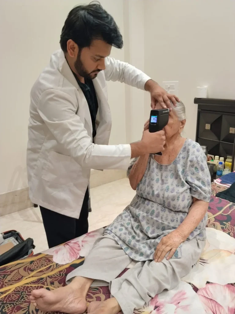 Doctor examining an elderly woman seated on her bed
