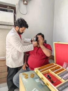 Optometrist using a portable eye scanner next to a trial lens set