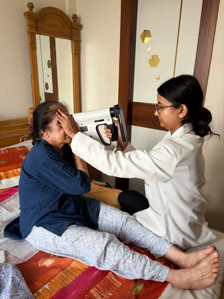 Optometrist examining a woman seated on her bed