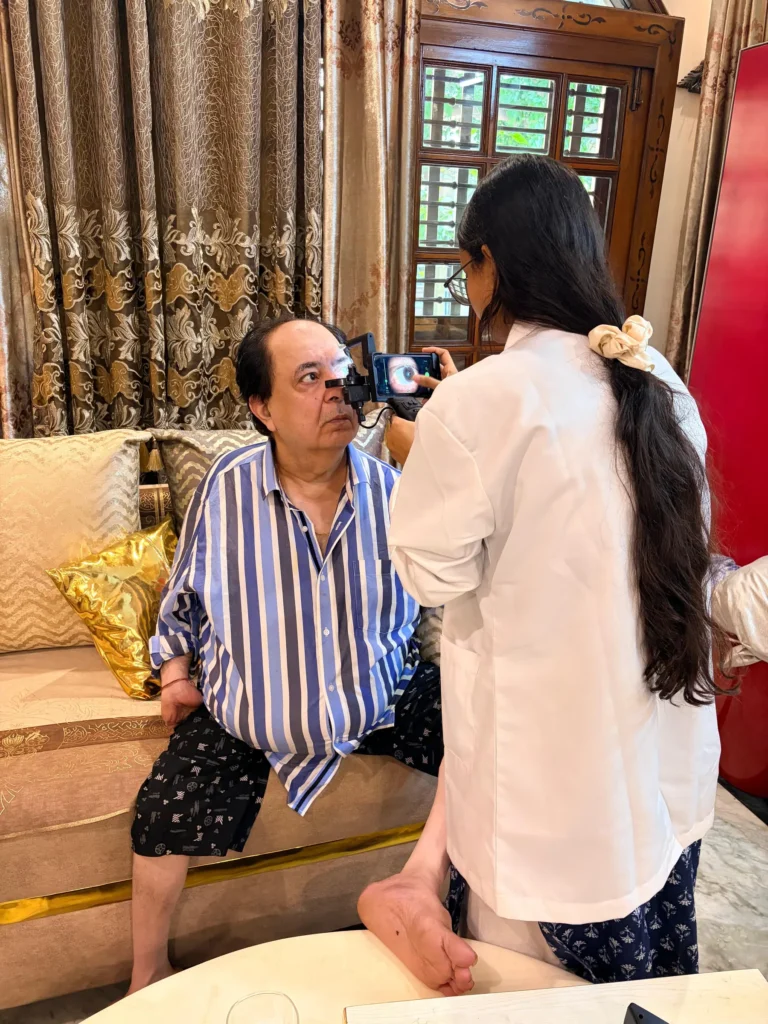 Optometrist checking a man's eyes on his sofa